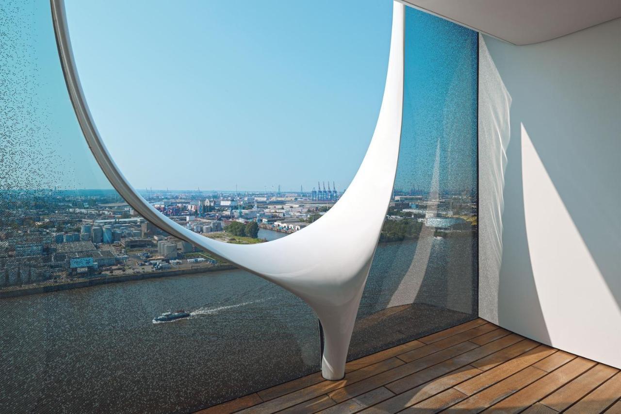The Westin Hamburg Elbphilharmonie Hotel Exterior photo The photo showcases a modern architectural interior featuring a large, uniquely designed window that creates a dramatic visual effect. The window has an organic, flowing shape, resembling a sculptural element, and is made of glass that allows natural