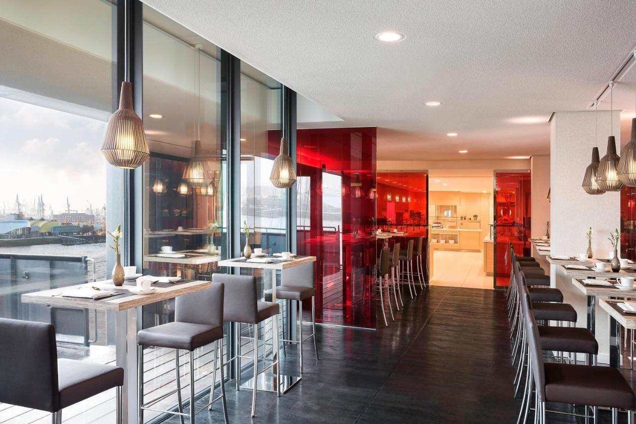 The Westin Hamburg Elbphilharmonie Hotel Exterior photo The photo showcases a modern restaurant interior characterized by sleek design and contemporary decor. The space features a combination of large windows allowing natural light to filter in, creating an open and airy atmosphere. The walls are accented